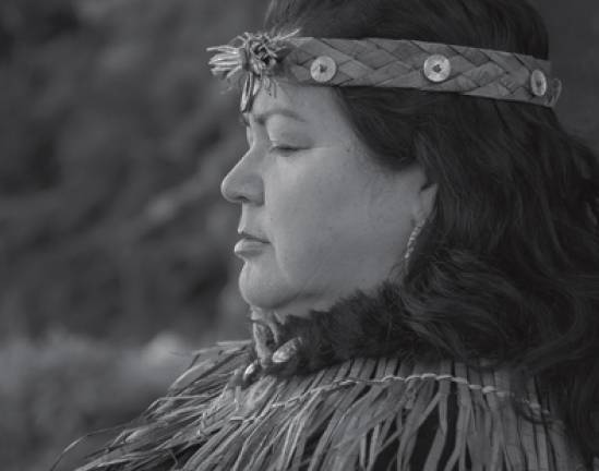 Greyscale photo of an Indigenous woman facing sideways, looking down